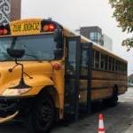 A parent watches as their student boards the school bus.