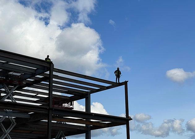 2 people stand on a steel-framed structure